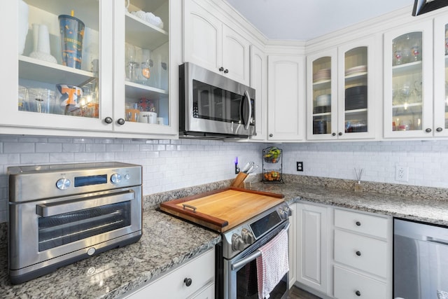 8202 Iris Rd, Chattanooga, TN 37421 - kitchen with appliances with stainless steel finishes, white cabinetry, decorative backsplash, and light stone countertops