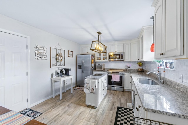 8202 Iris Rd, Chattanooga, TN 37421 - kitchen featuring appliances with stainless steel finishes, decorative backsplash, light wood-style flooring, and a chandelier
