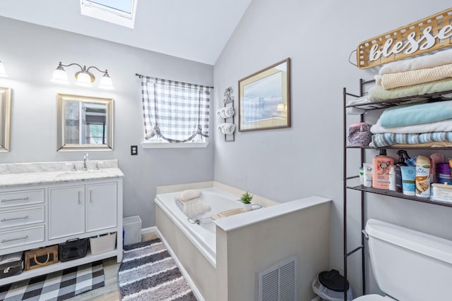 8202 Iris Rd, Chattanooga, TN 37421 - bathroom featuring a bath, a skylight, vanity, vaulted ceiling, and wood finished floors