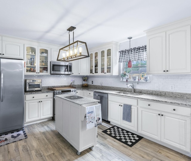 8202 Iris Rd, Chattanooga, TN 37421 - kitchen featuring stainless steel appliances, white cabinetry, decorative backsplash, and decorative light fixtures