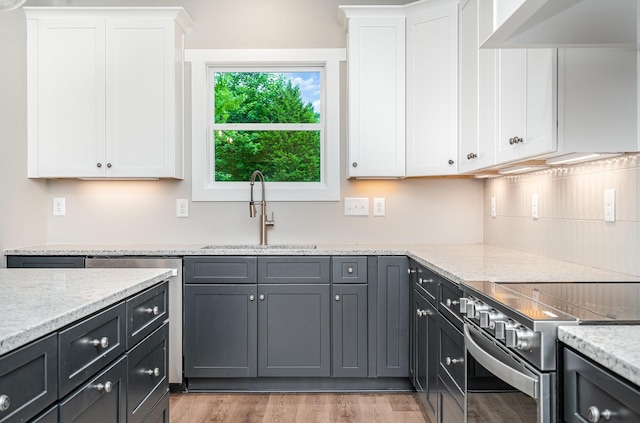 408 Harsh Ln, Castalian Springs, TN 37031 - kitchen featuring stainless steel electric stove, white cabinets, light wood-style floors, and light stone counters