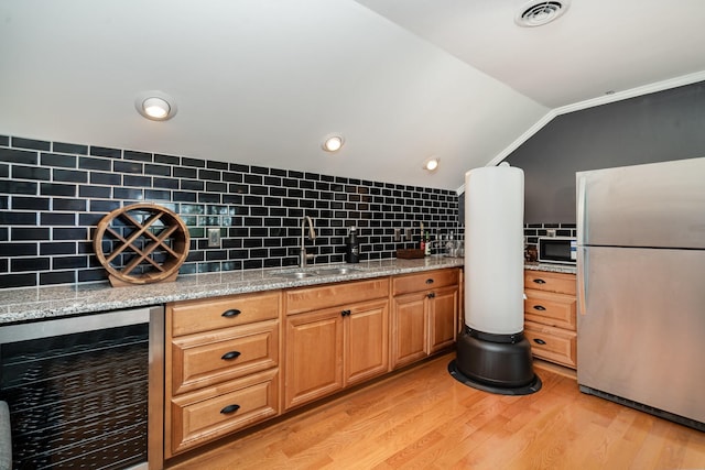 1640 Eno Rd, Dickson, TN 37055 - kitchen with freestanding refrigerator, wine cooler, decorative backsplash, light wood-style floors, and light stone counters