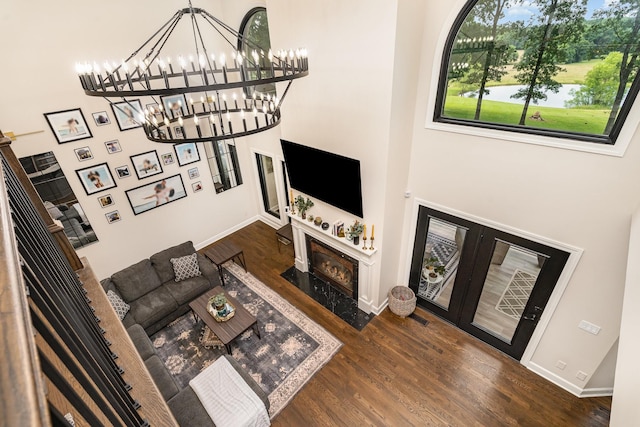 1640 Eno Rd, Dickson, TN 37055 - living area featuring wood finished floors, a fireplace with flush hearth, a chandelier, a towering ceiling, and french doors