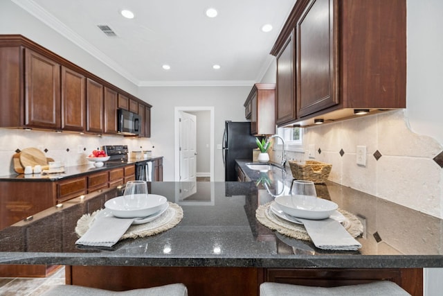 4613 Scottish Dr, Murfreesboro, TN 37128 - kitchen with black appliances, dark stone countertops, decorative backsplash, a kitchen bar, and recessed lighting