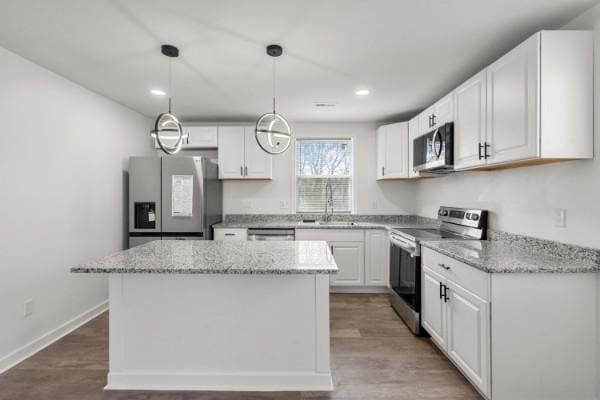 3211 Mayer Ln, Nashville, TN 37218 - kitchen featuring stainless steel appliances, a kitchen island, white cabinetry, recessed lighting, and light stone countertops
