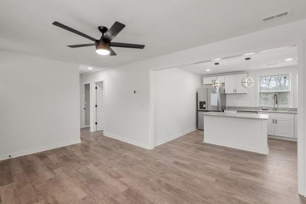 3211 Mayer Ln, Nashville, TN 37218 - kitchen featuring stainless steel refrigerator with ice dispenser, light wood-style floors, a kitchen island, light countertops, and recessed lighting
