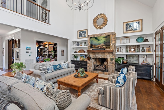 1049 Holly Tree Gap Rd, Brentwood, TN 37027 - living room featuring high vaulted ceiling, a stone fireplace, built in features, wood finished floors, and a chandelier