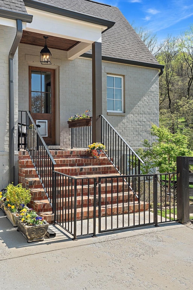 1049 Holly Tree Gap Rd, Brentwood, TN 37027 - doorway to property featuring brick siding, a shingled roof, and a porch