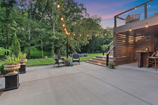 1049 Holly Tree Gap Rd, Brentwood, TN 37027 - patio terrace at dusk featuring a patio area, stairs, and a lawn