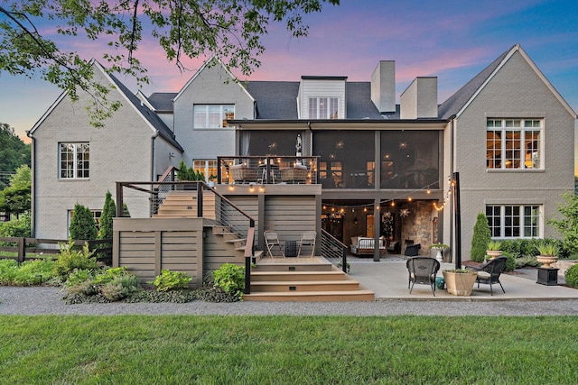 1049 Holly Tree Gap Rd, Brentwood, TN 37027 - back of property at dusk with a sunroom, a patio, stairs, and a wooden deck