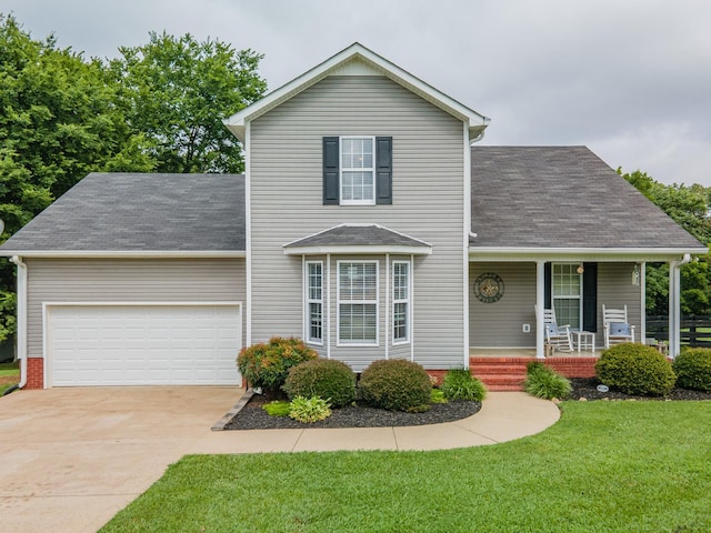216 Desperado Ave, Pulaski, TN 38478 - traditional-style house featuring an attached garage, a porch, a shingled roof, concrete driveway, and a front lawn