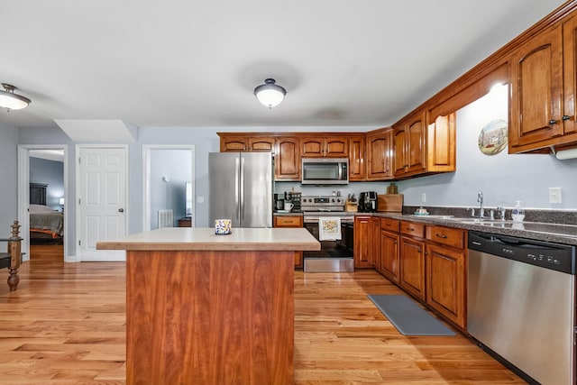 216 Desperado Ave, Pulaski, TN 38478 - kitchen with appliances with stainless steel finishes, light wood-style flooring, brown cabinets, and a kitchen island