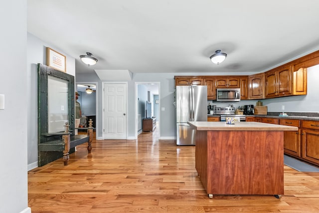 216 Desperado Ave, Pulaski, TN 38478 - kitchen featuring stainless steel appliances, light wood finished floors, a center island, and brown cabinets