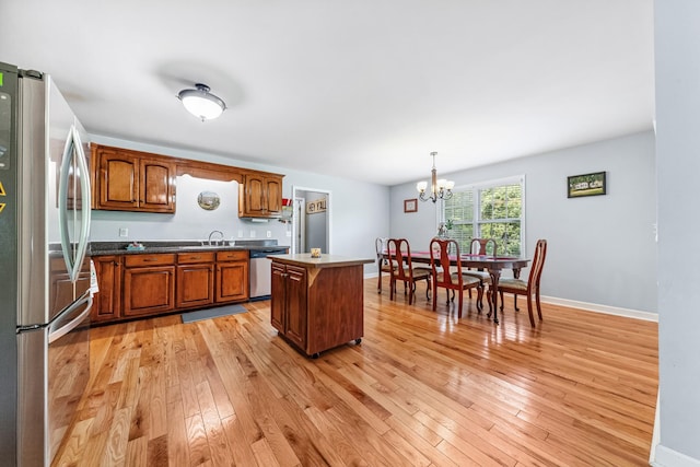216 Desperado Ave, Pulaski, TN 38478 - kitchen with appliances with stainless steel finishes, a chandelier, light wood-type flooring, a kitchen island, and brown cabinets