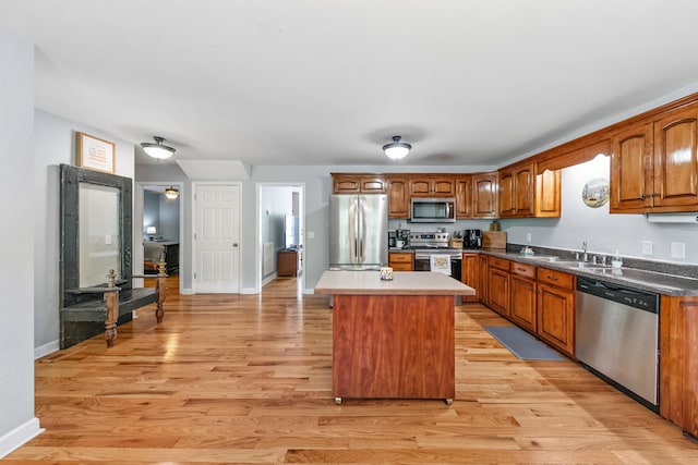 216 Desperado Ave, Pulaski, TN 38478 - kitchen with stainless steel appliances, light wood-style flooring, a center island, and brown cabinetry