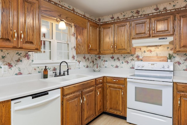 140 Janes Way NE, Cleveland, TN 37323 - kitchen with under cabinet range hood, white appliances, wallpapered walls, and brown cabinetry