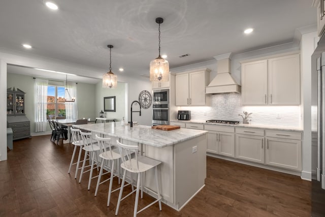 5726 Bridgemore Blvd, Murfreesboro, TN 37129 - kitchen with stainless steel appliances, white cabinetry, an island with sink, a kitchen bar, and custom range hood