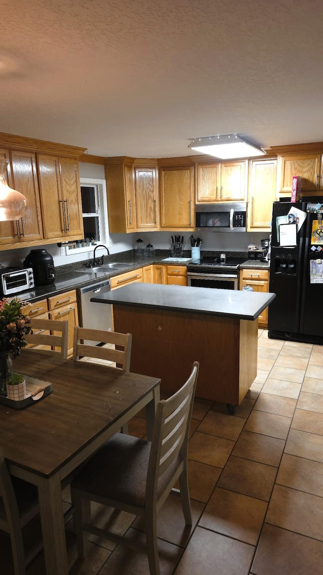 145 Michelle Ln, Winchester, TN 37398 - kitchen with appliances with stainless steel finishes, light tile patterned floors, dark countertops, and a center island