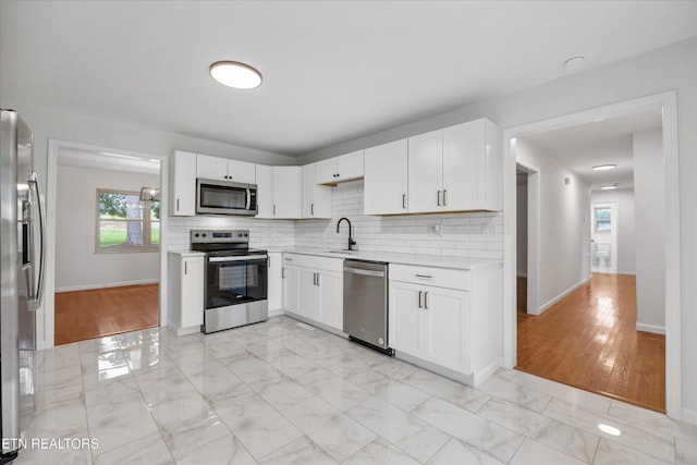 1701 Talbott Kansas Rd, Talbott, TN 37877 - kitchen featuring appliances with stainless steel finishes, light countertops, decorative backsplash, and white cabinetry