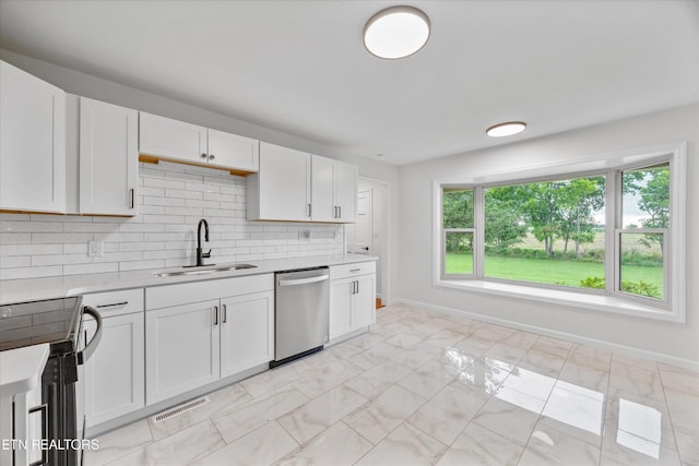 1701 Talbott Kansas Rd, Talbott, TN 37877 - kitchen featuring appliances with stainless steel finishes, light countertops, white cabinetry, tasteful backsplash, and light marble finish flooring