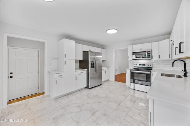 1701 Talbott Kansas Rd, Talbott, TN 37877 - kitchen with stainless steel appliances, light countertops, white cabinets, tasteful backsplash, and light marble finish flooring