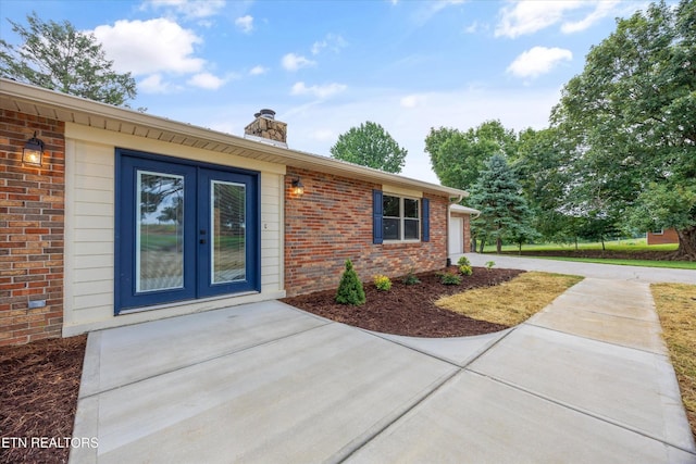 1701 Talbott Kansas Rd, Talbott, TN 37877 - view of exterior entry with brick siding, a chimney, french doors, driveway, and an attached garage