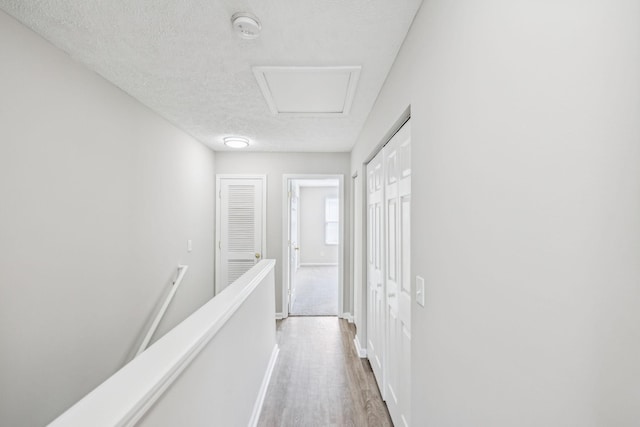 5428 Cedar Ash Xing, Antioch, TN 37013 - corridor with light wood-style flooring, attic access, a textured ceiling, and an upstairs landing