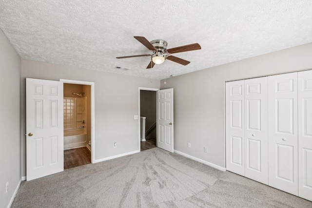 5428 Cedar Ash Xing, Antioch, TN 37013 - unfurnished bedroom featuring carpet flooring, a closet, a textured ceiling, connected bathroom, and a ceiling fan