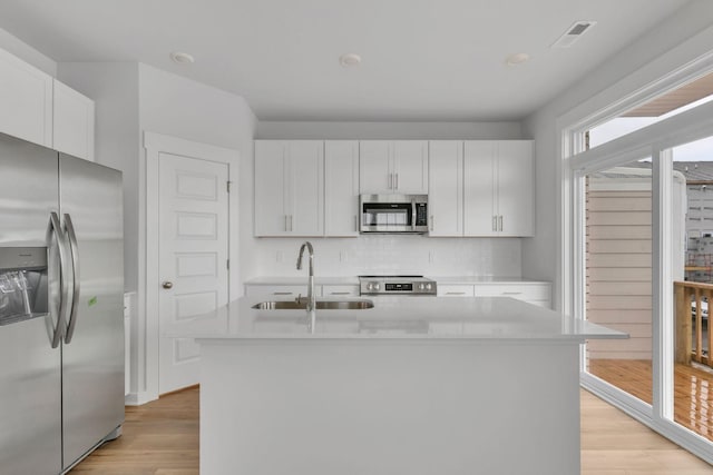 510 Hinton St, Lebanon, TN 37090 - kitchen featuring appliances with stainless steel finishes, light countertops, light wood-style floors, backsplash, and white cabinetry