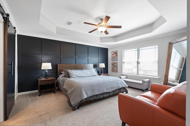 509 Eagleview Dr, Eagleville, TN 37060 - bedroom with a tray ceiling, a decorative wall, a barn door, light carpet, and crown molding