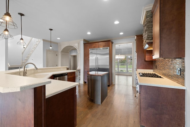 1118 Averwater Run, Murfreesboro, TN 37128 - kitchen with a large island with sink, appliances with stainless steel finishes, backsplash, arched walkways, and recessed lighting
