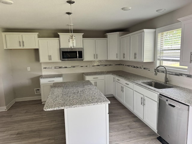 1175 Ewing Way, Clarksville, TN 37043 - kitchen with stainless steel appliances, tasteful backsplash, a kitchen island, light stone counters, and wood finished floors