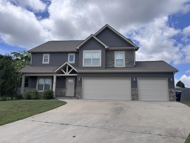 1175 Ewing Way, Clarksville, TN 37043 - view of front of house with driveway, a front lawn, stone siding, an attached garage, and roof with shingles