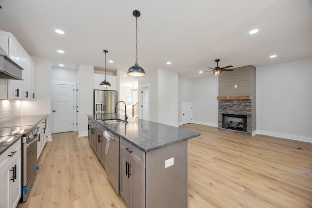 403 Boren St, Springfield, TN 37172 - kitchen featuring stainless steel appliances, ceiling fan, an island with sink, light wood-style flooring, and white cabinetry