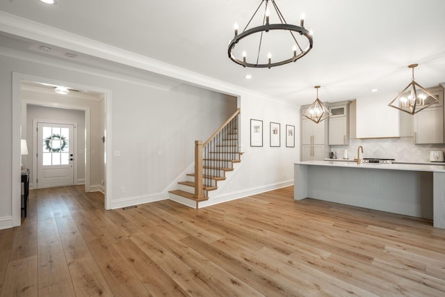 1015 Amelia Ct, Chattanooga, TN 37412 - kitchen with a chandelier, light countertops, decorative backsplash, light wood-style flooring, and crown molding