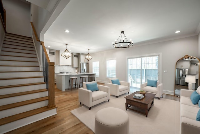 1015 Amelia Ct, Chattanooga, TN 37412 - living room featuring a chandelier, stairway, recessed lighting, light wood-style floors, and ornamental molding