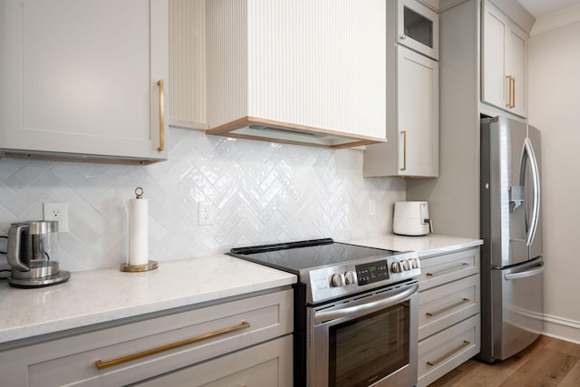 1015 Amelia Ct, Chattanooga, TN 37412 - kitchen featuring stainless steel appliances, light wood finished floors, light stone countertops, decorative backsplash, and glass insert cabinets