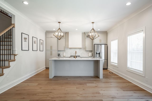 1015 Amelia Ct, Chattanooga, TN 37412 - kitchen with stainless steel fridge with ice dispenser, a chandelier, a center island with sink, light countertops, and decorative backsplash
