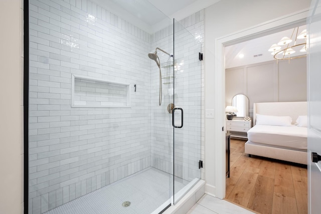 1015 Amelia Ct, Chattanooga, TN 37412 - bathroom featuring ensuite bath, a stall shower, a chandelier, and wood finished floors