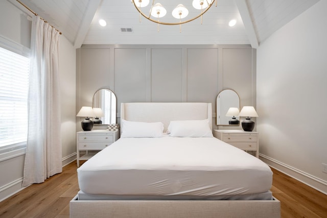 1015 Amelia Ct, Chattanooga, TN 37412 - bedroom with vaulted ceiling, a decorative wall, light wood finished floors, and a chandelier