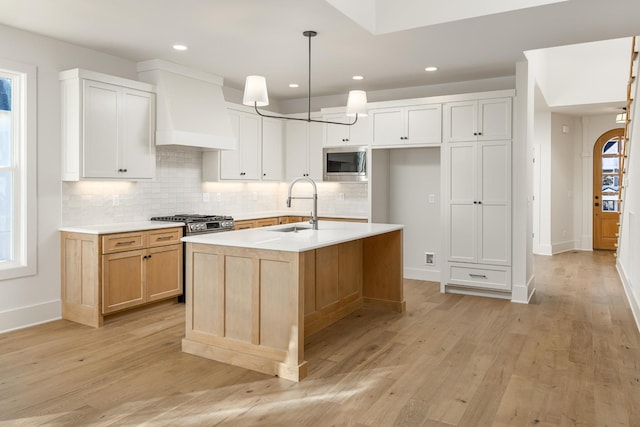 8668 Woodbury Acre Ct, Harrison, TN 37341 - kitchen with stainless steel microwave, custom exhaust hood, decorative backsplash, light wood-style floors, and recessed lighting
