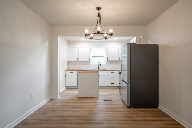35 Agnes Ave, Chattanooga, TN 37406 - kitchen with freestanding refrigerator, wood counters, a chandelier, white cabinets, and tasteful backsplash