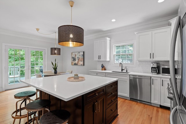 715 Forest Ave, Chattanooga, TN 37405 - kitchen featuring appliances with stainless steel finishes, a kitchen bar, light countertops, white cabinetry, and decorative backsplash