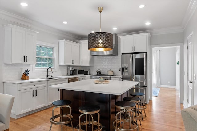 715 Forest Ave, Chattanooga, TN 37405 - kitchen with appliances with stainless steel finishes, a kitchen bar, white cabinetry, light wood-style flooring, and a kitchen island