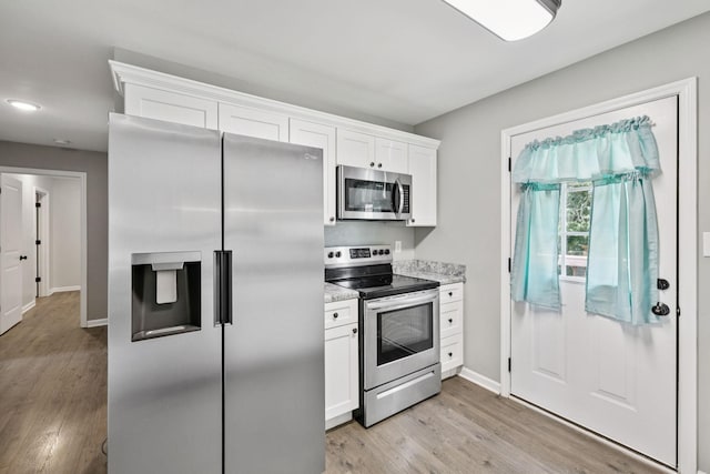 521 5th Ave N, Lewisburg, TN 37091 - kitchen with appliances with stainless steel finishes, light wood-style flooring, white cabinets, and light stone counters