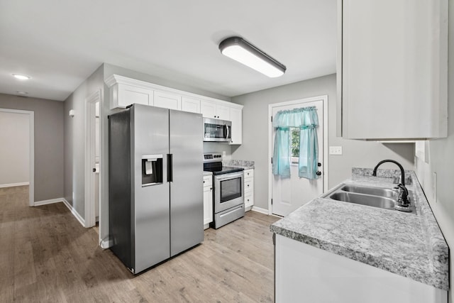 521 5th Ave N, Lewisburg, TN 37091 - kitchen with appliances with stainless steel finishes, light wood finished floors, white cabinets, and light countertops