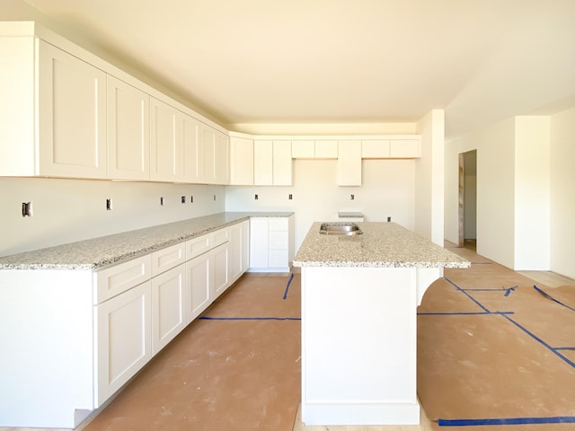 305 Towles Ave Unit A, Mcminnville, TN 37110 - kitchen with a center island, white cabinets, light stone counters, and concrete floors