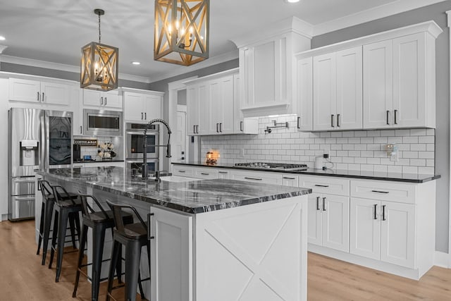 1014 Douglas Ct, Dickson, TN 37055 - kitchen featuring appliances with stainless steel finishes, crown molding, a chandelier, recessed lighting, and light wood-type flooring