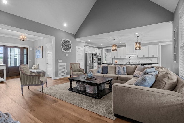 1014 Douglas Ct, Dickson, TN 37055 - living area featuring recessed lighting, crown molding, light wood-type flooring, a chandelier, and high vaulted ceiling