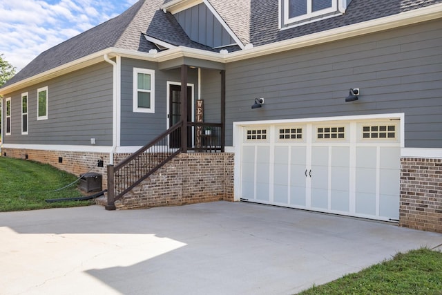 1014 Douglas Ct, Dickson, TN 37055 - view of exterior entry with concrete driveway, board and batten siding, a shingled roof, and an attached garage